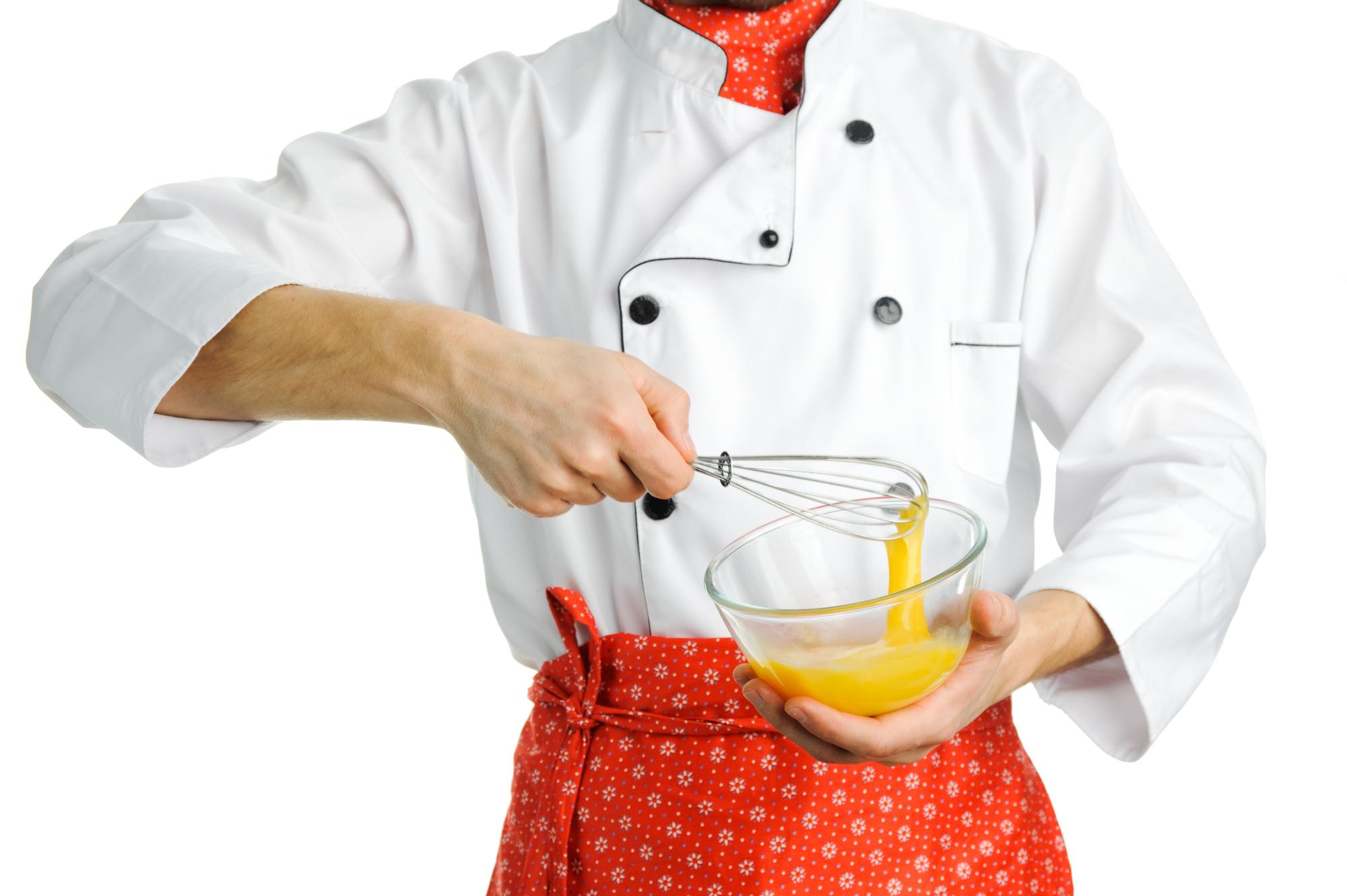 Chef che prepara una salsa in una cucina luminosa